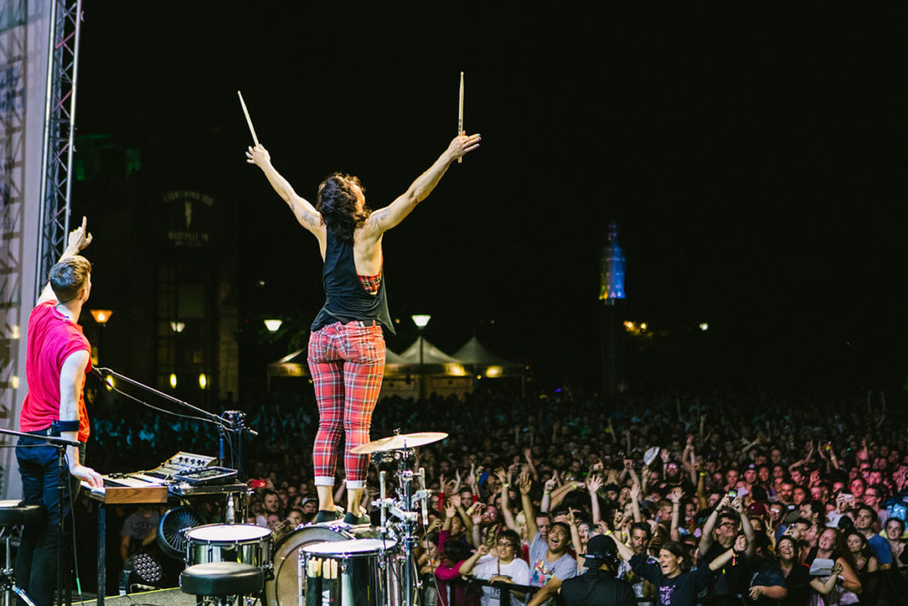 Matt & Kim interacting with the audience, Kim standing on top of her drum set